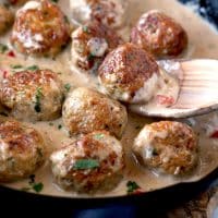 Chicken meatballs with creamy sauce in a skillet