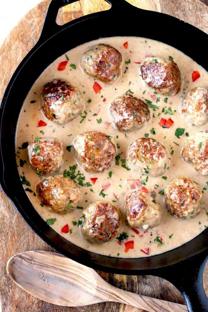 Top view of a skillet filled with chicken meatballs in creamy Cajun sauce
