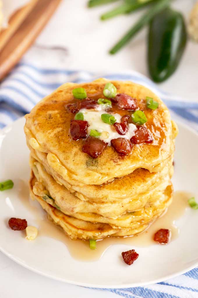 Corn and bacon pancakes on a white plate.