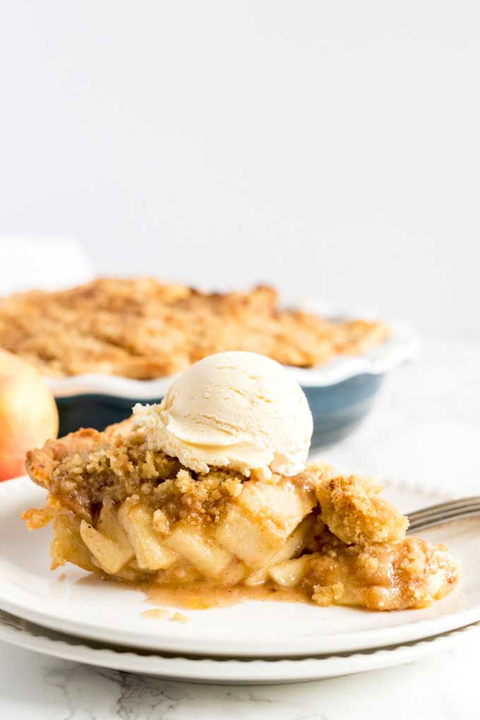 A slice of Dutch apple pie topped with vanilla ice cream