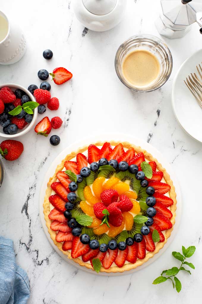 Top view of fresh fruit tart on a white platter.