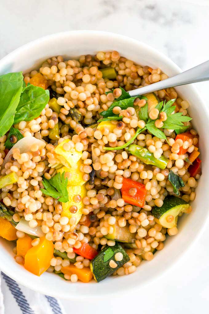 White salad bowl with pearl couscous and grilled vegetables.
