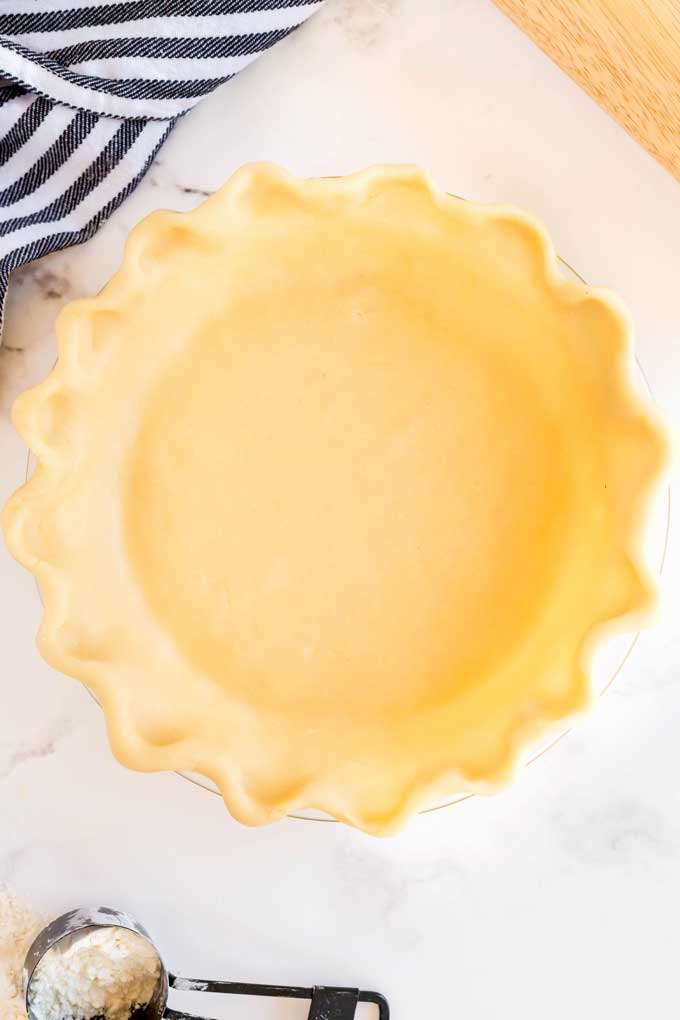 An unbaked homemade pie crust in a pie dish.