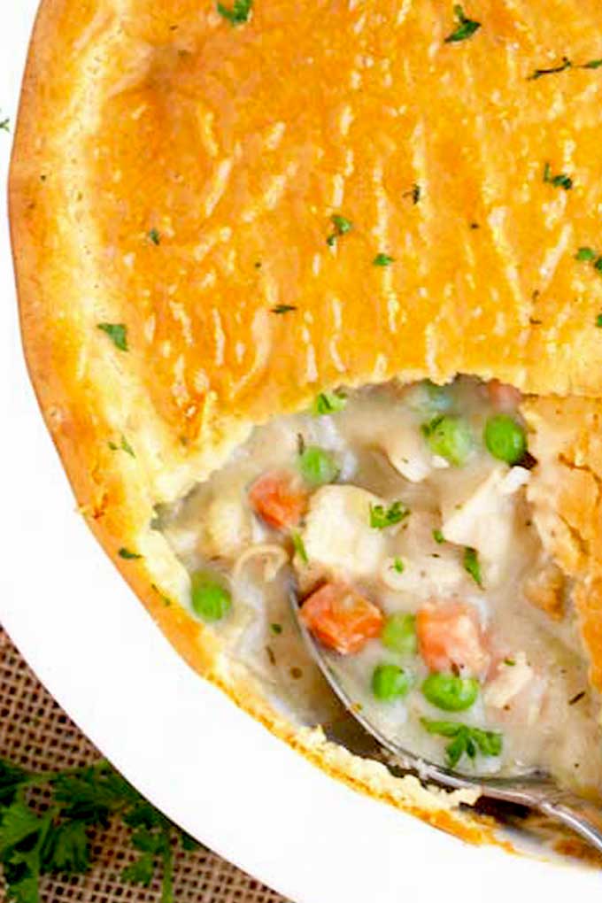 Turkey pot pie getting scooped out from a round baking pie dish.