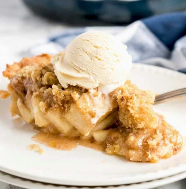 Apple Pie with streusel topping on a white plate.