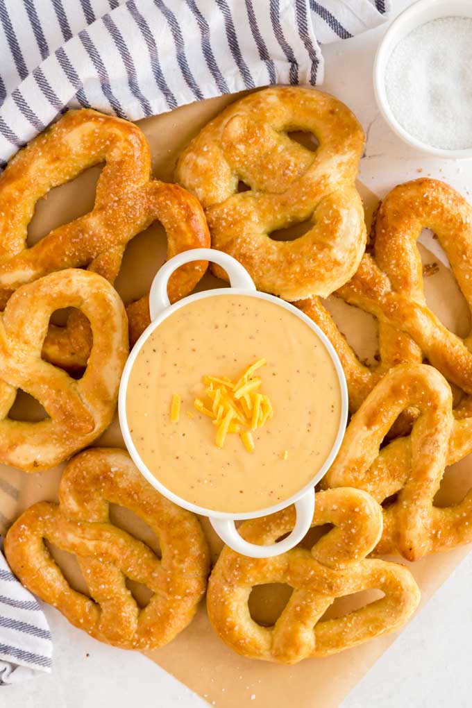 Golden brown soft pretzels surrounding a bowl of dipping sauce