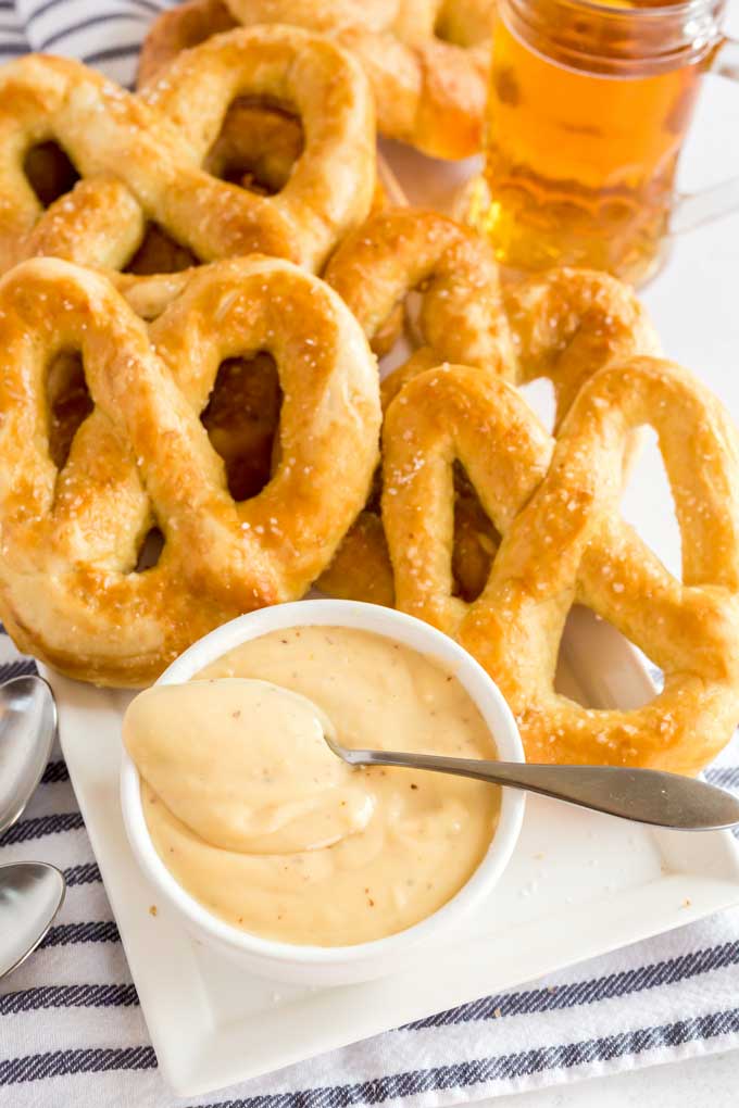 Homemade soft pretzels around a bowl of beer cheese dipping sauce