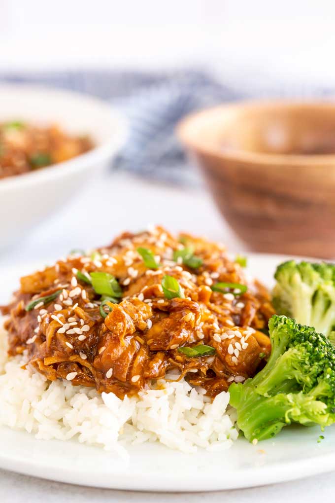 Shredded  chicken over white rice with a side of broccoli.