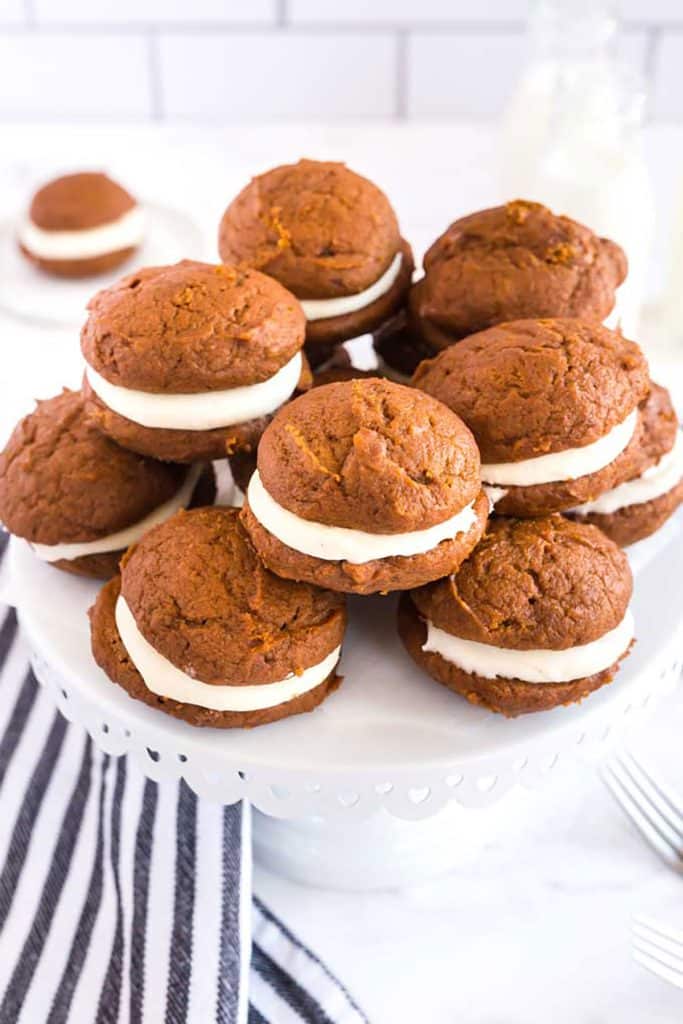 A group of homemade whoopie cookies on a cake platter.