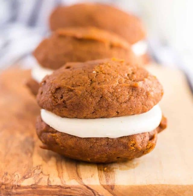 Close up of a pumpkin whoopie pie filled with cream cheese frosting.