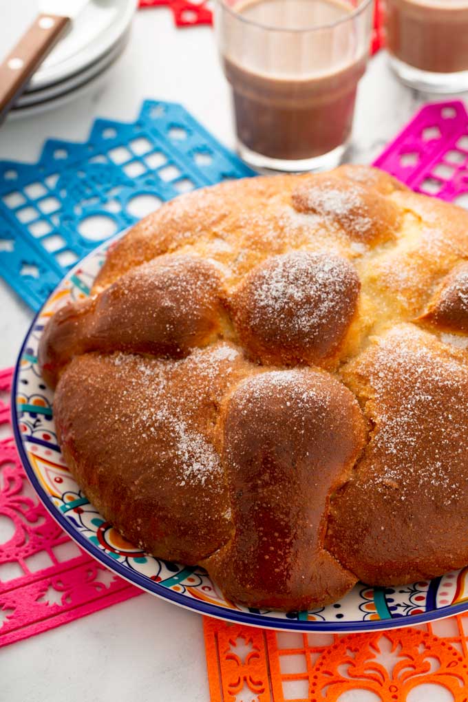 A round loaf of sweet Mexican bread (Pan de Muerto) on a plate.