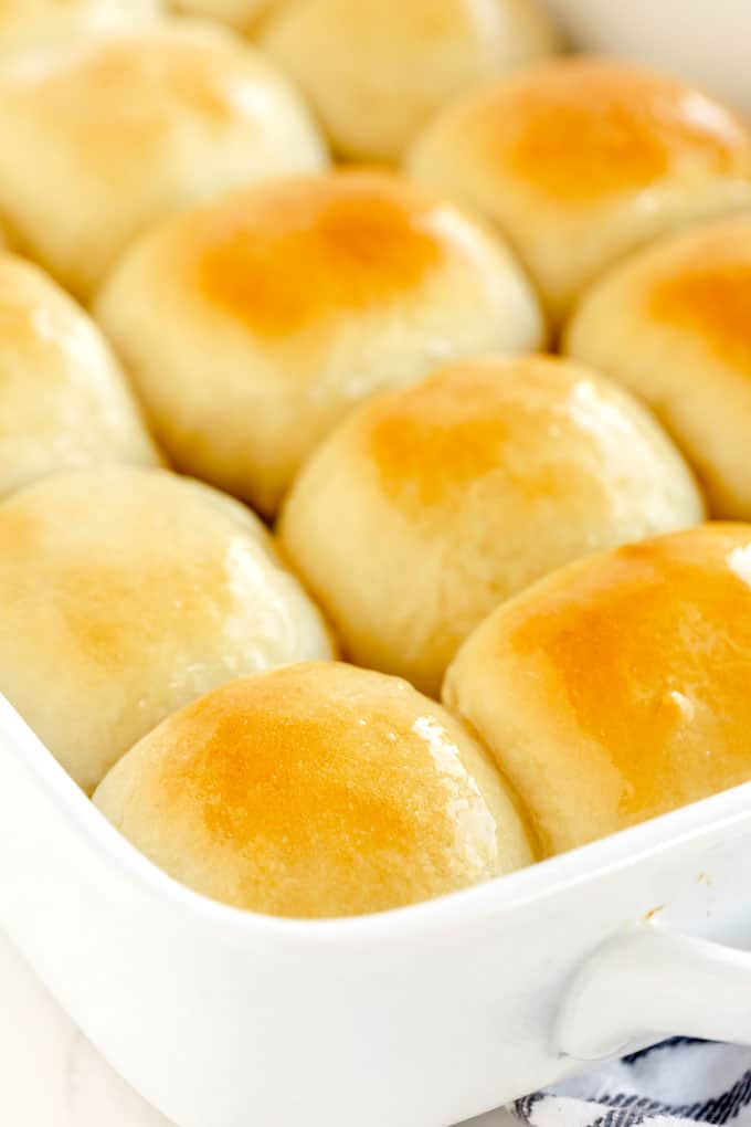 Close up view of soft dinner rolls in a baking pan.