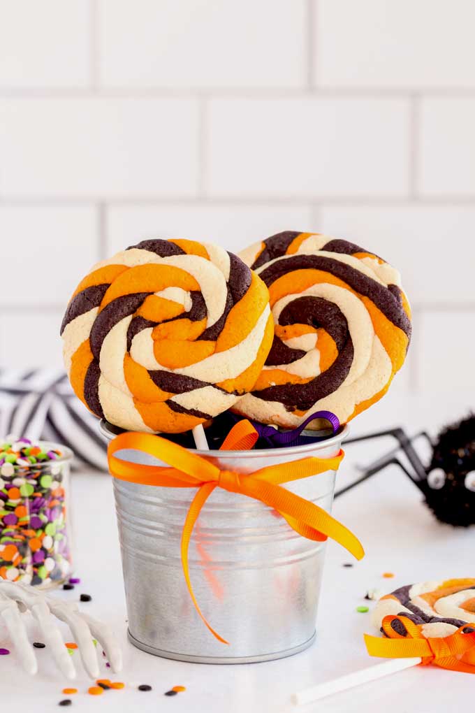 A small gift bucket with two Halloween cookies.