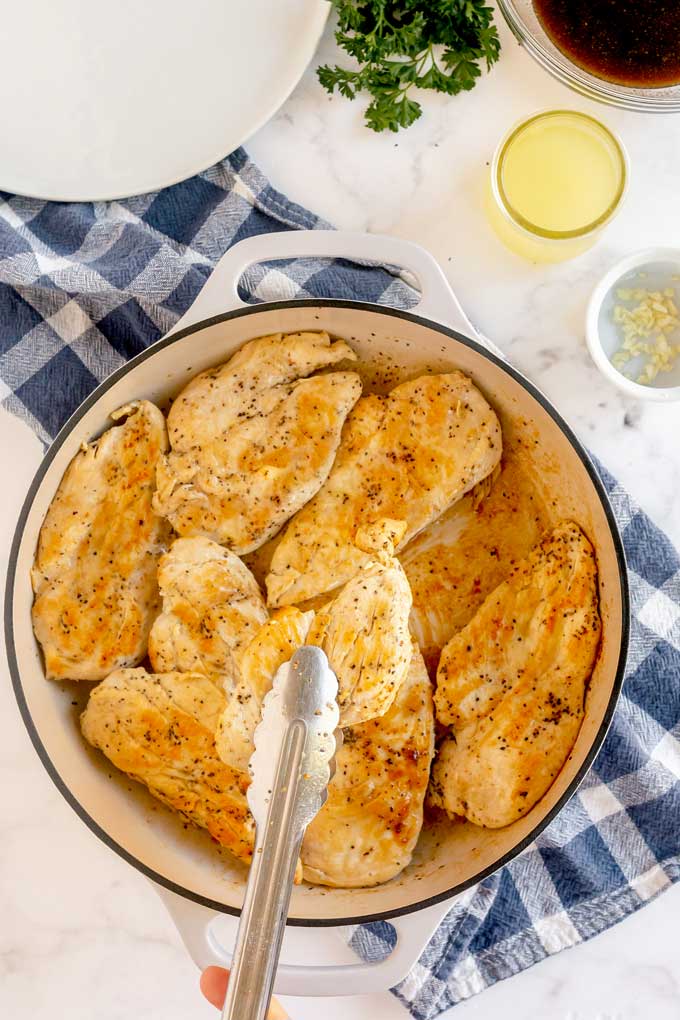 Chicken breast searing in a large skillet