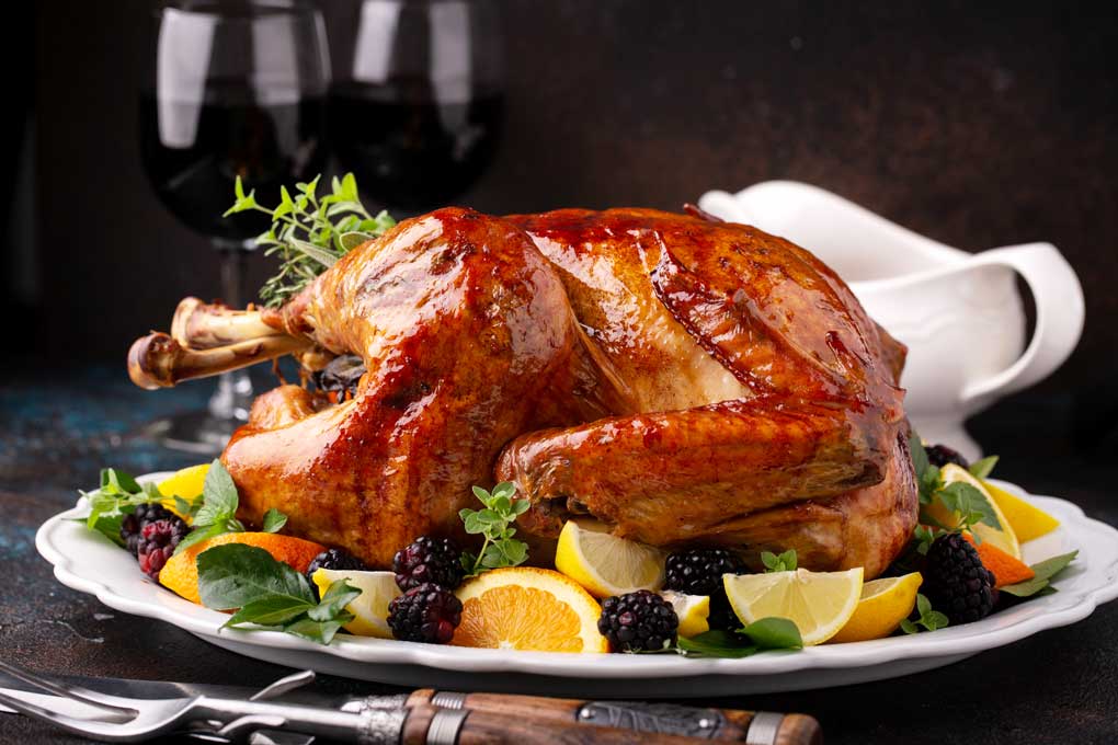 Side view of a golden brown roast turkey on a serving platter
