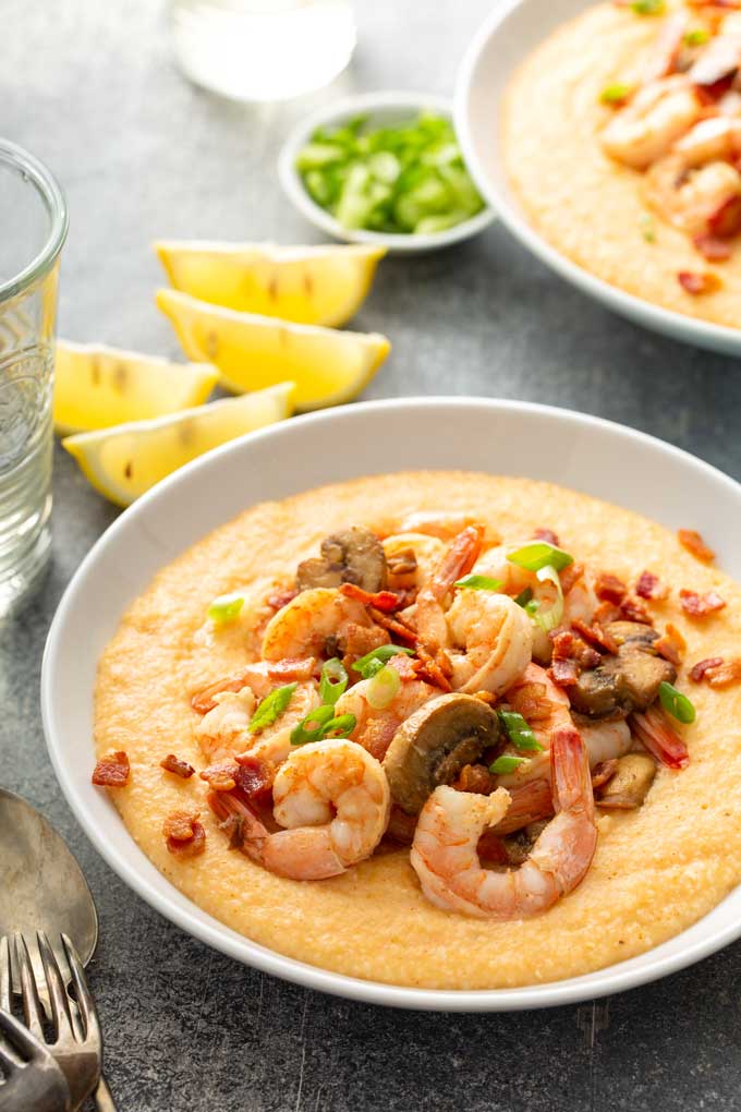 Bowls filled with cheesy grits and topped with shrimp,