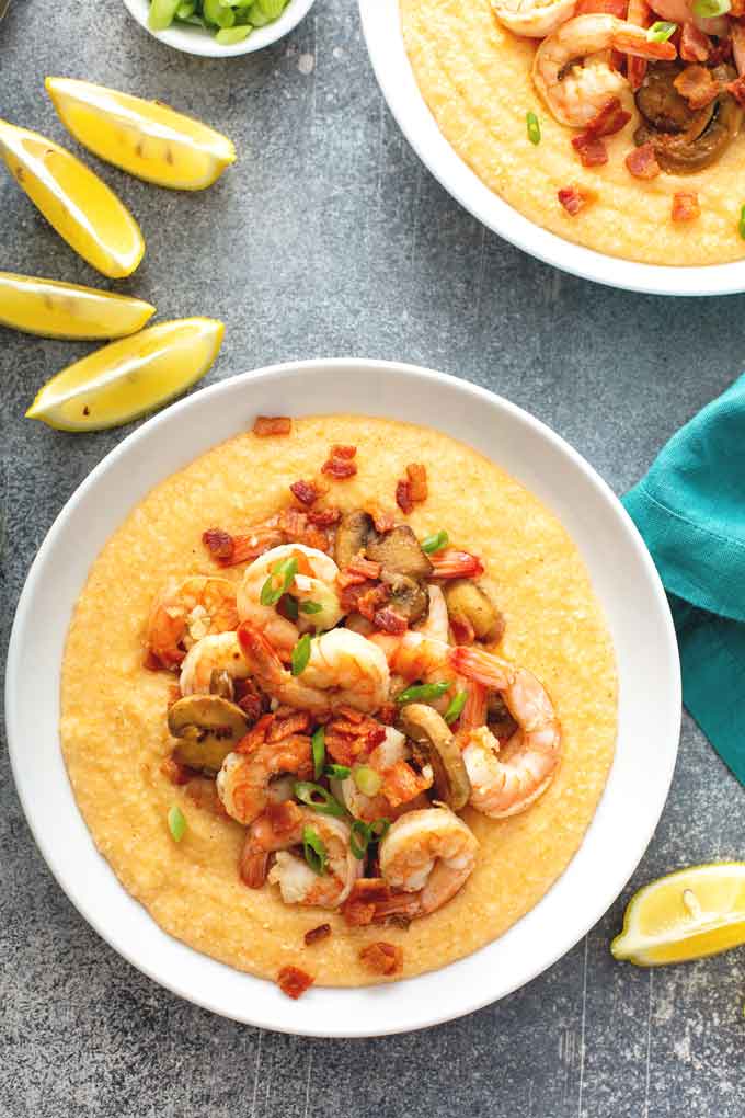 top view of two Bowls filled with cheesy grits and topped with shrimp,