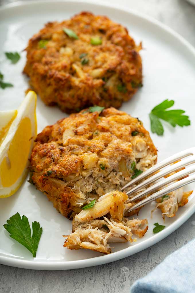 Fork flaking a golden brown crab patty