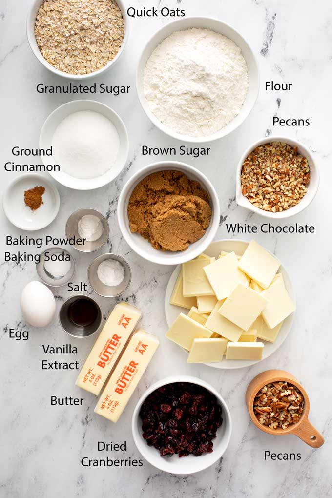 ingredients to make cranberry oatmeal cookies over a marble surface