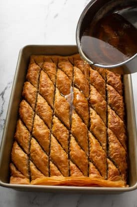 Pouring syrup over baked baklava