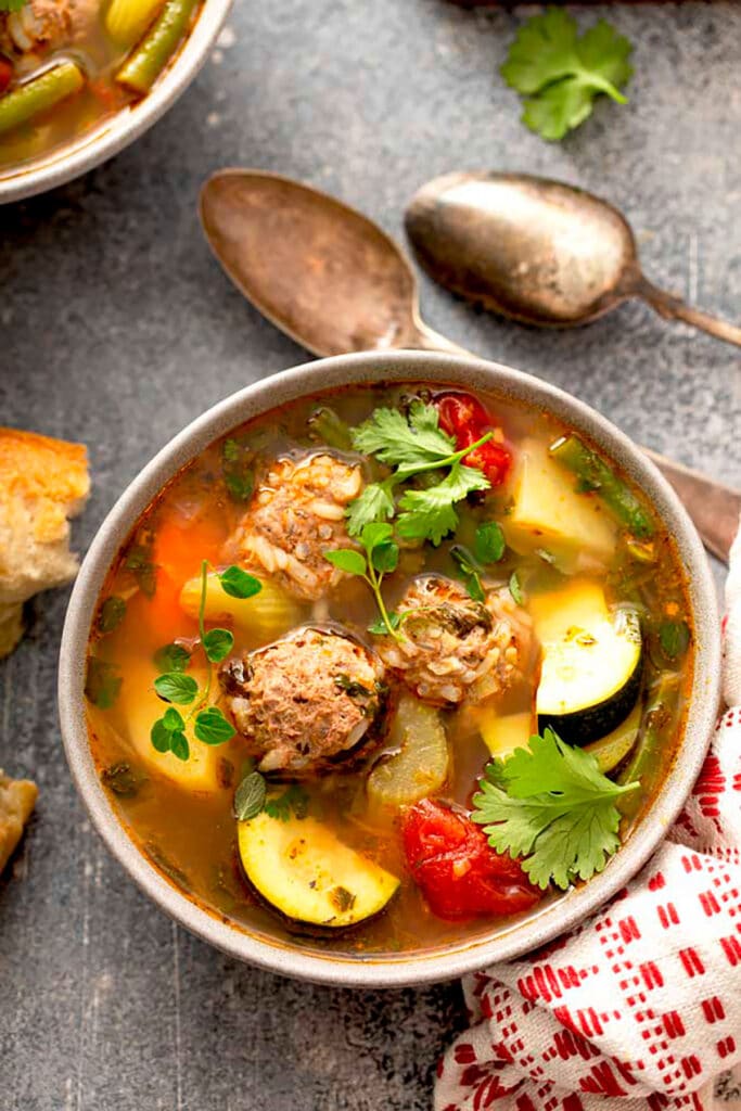 A bowl with Albondigas Soup garnished with cilantro