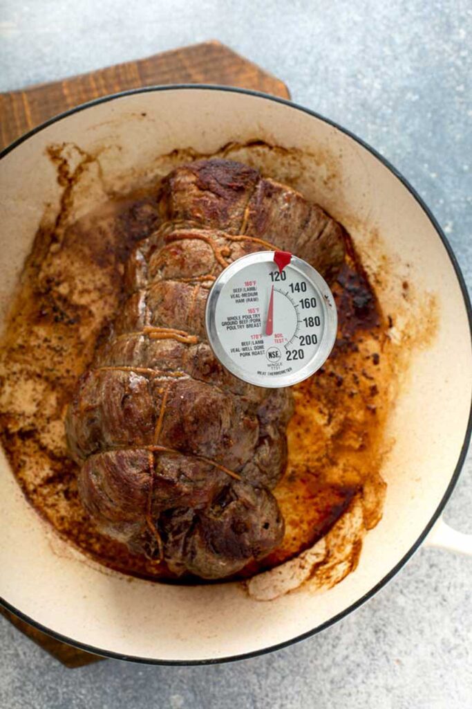 Checking the temperature of a tenderloin of beef with s meat thermometer