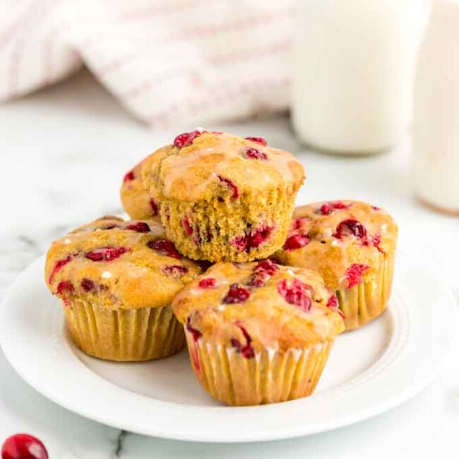 Stack of cranberry orange muffins on a white plate