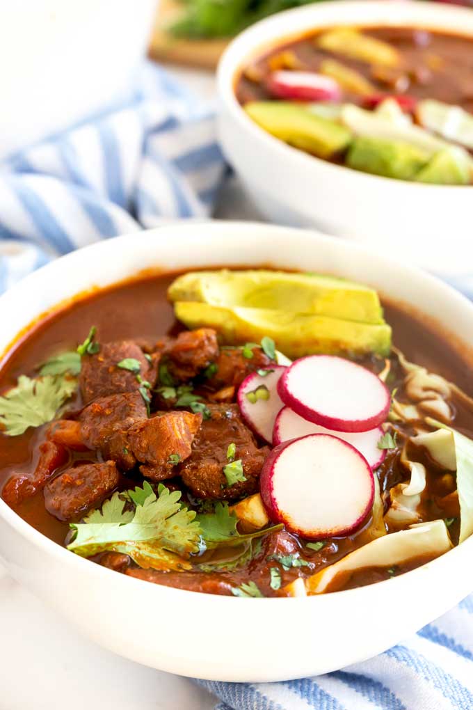 A white bowl filled with Mexican pozole soup