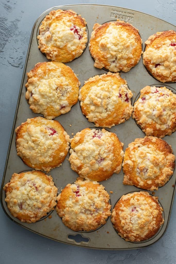 Freshly baked Raspberry muffins with crumb streusel topping in a baking tray