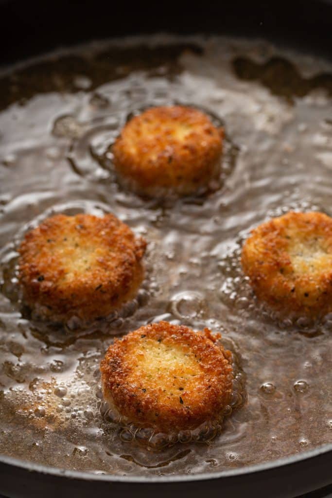 frying goat cheese slices covered in flour