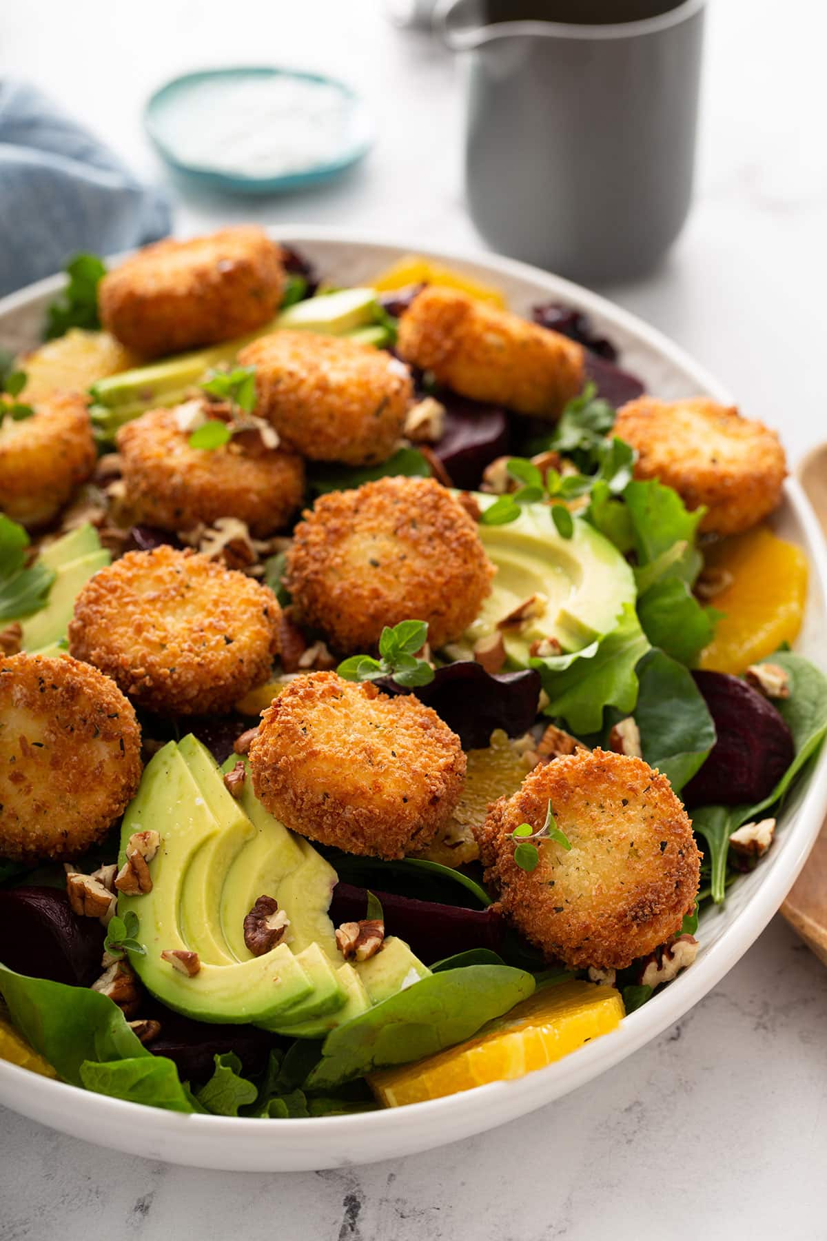 Beet salad with crispy goat cheese on a white platter