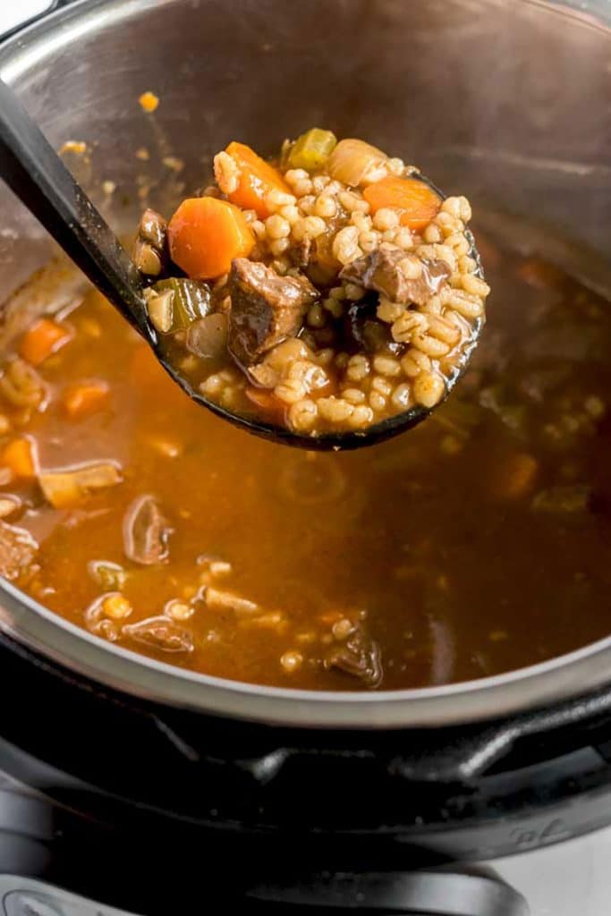 A big scoop of beef soup with barley from an instant pot