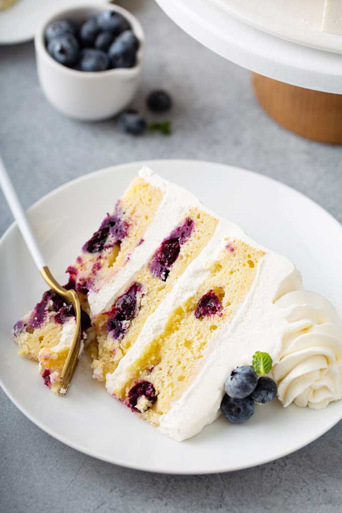 A sliced of Lemon blueberry cake on a plate.