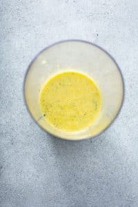 lemon vinaigrette in the cup of an inmersion blender