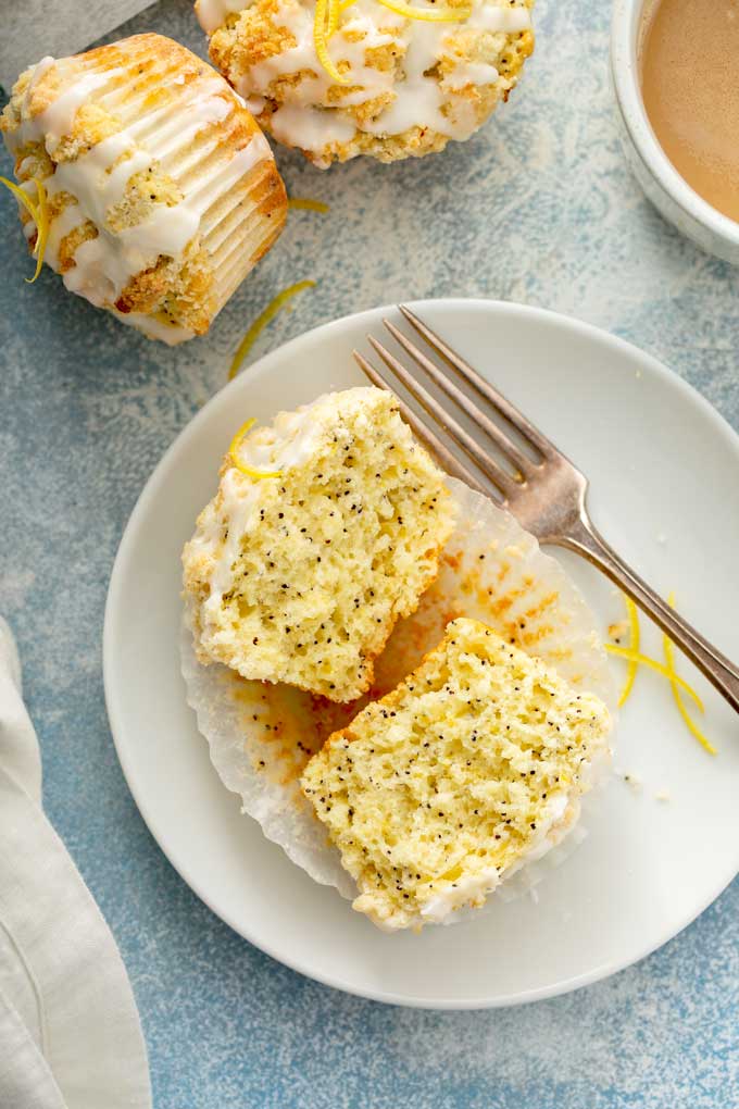 A lemon poppy seed muffin cut in half on a white plate