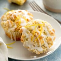 two Lemon muffins with lemon glaze on a white plate