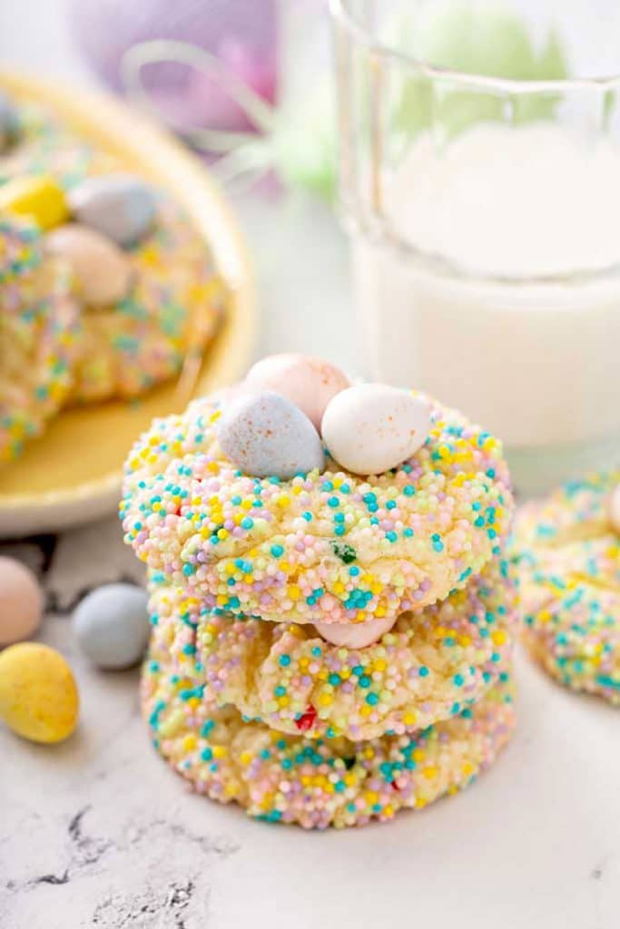 Three Easter cookies stacked together on a white marbled surface.