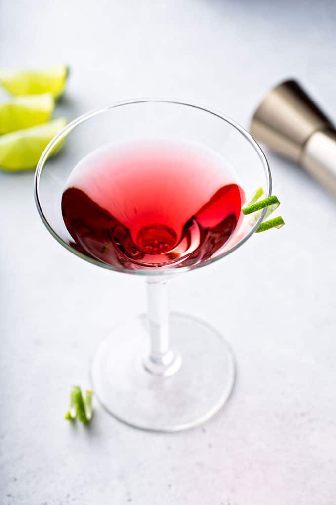 Top view of a cosmopolitan martini with a lime twist