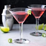 Two Cosmopolitan Martinis on a white surface