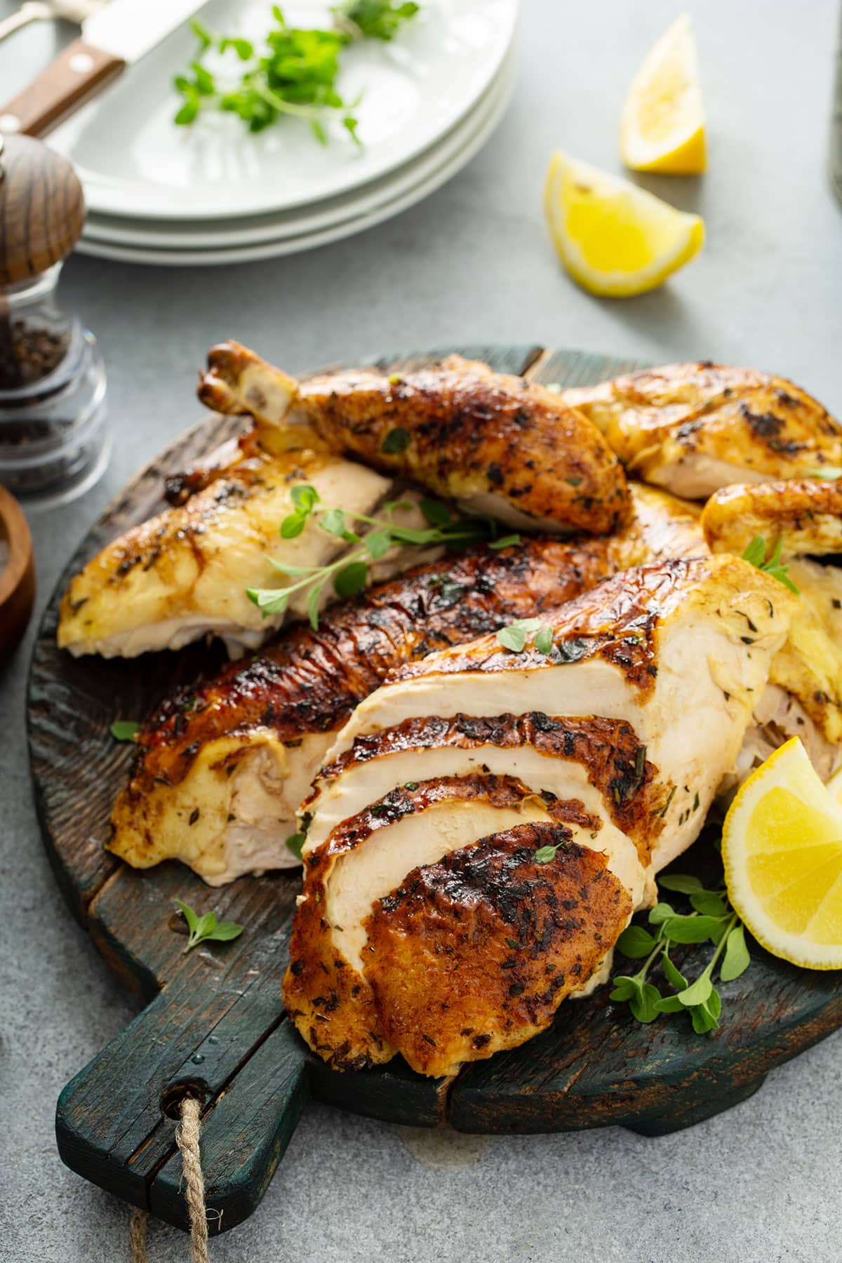 Roasted chicken carved on a wooden board.