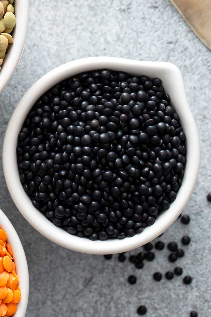 Black lentils in a white bowl