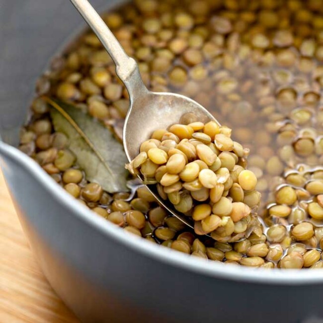 Spoon picking lentils from a pot