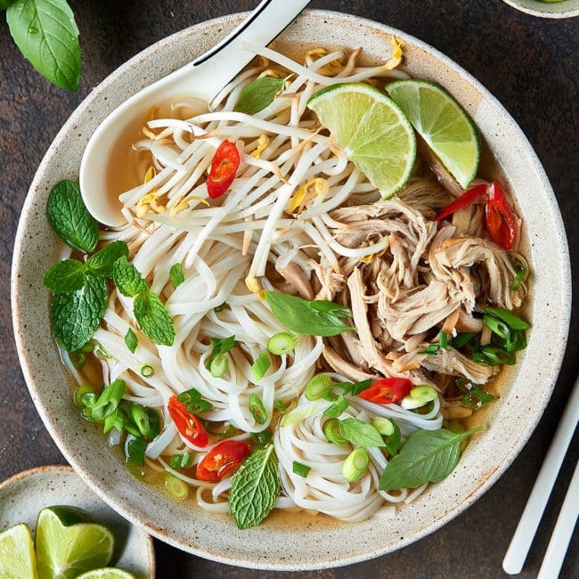 Chicken pho with fresh herbs in a soup bowl