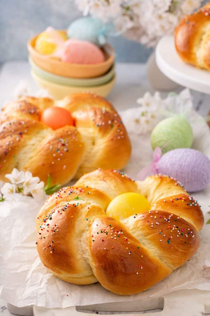 Golden brown Italian bread wreath with a colorful egg in the middle sprinkled with nonpareils