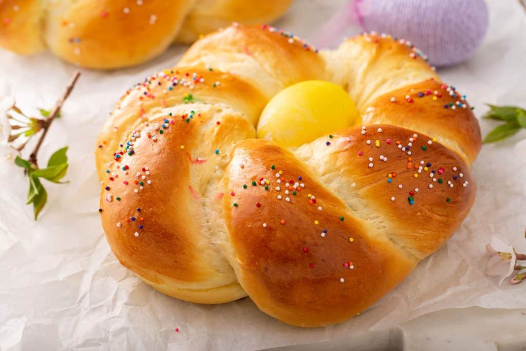 Round Easter bread wreath with a yellow Easter egg in the middle