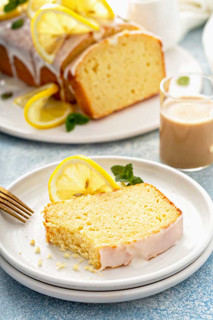 A slice of lemon bread with glaze on a white plate.