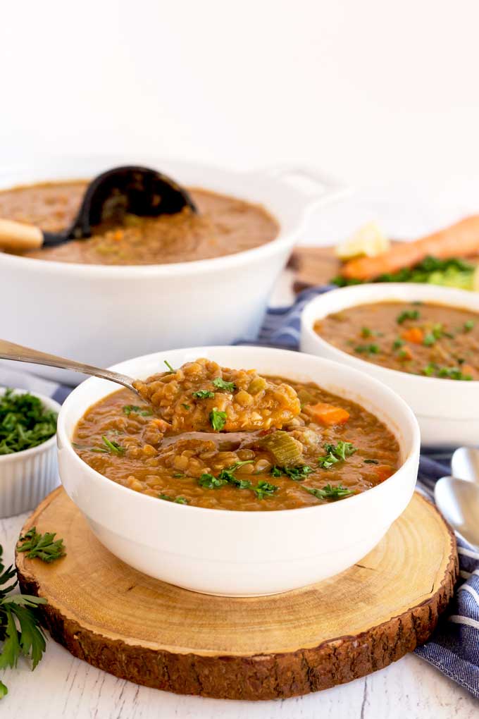 A spoonful of soup lifting from a bowl of soup