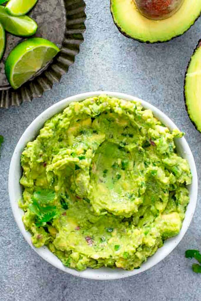 top view of a white bowl of Homemade Guacamole