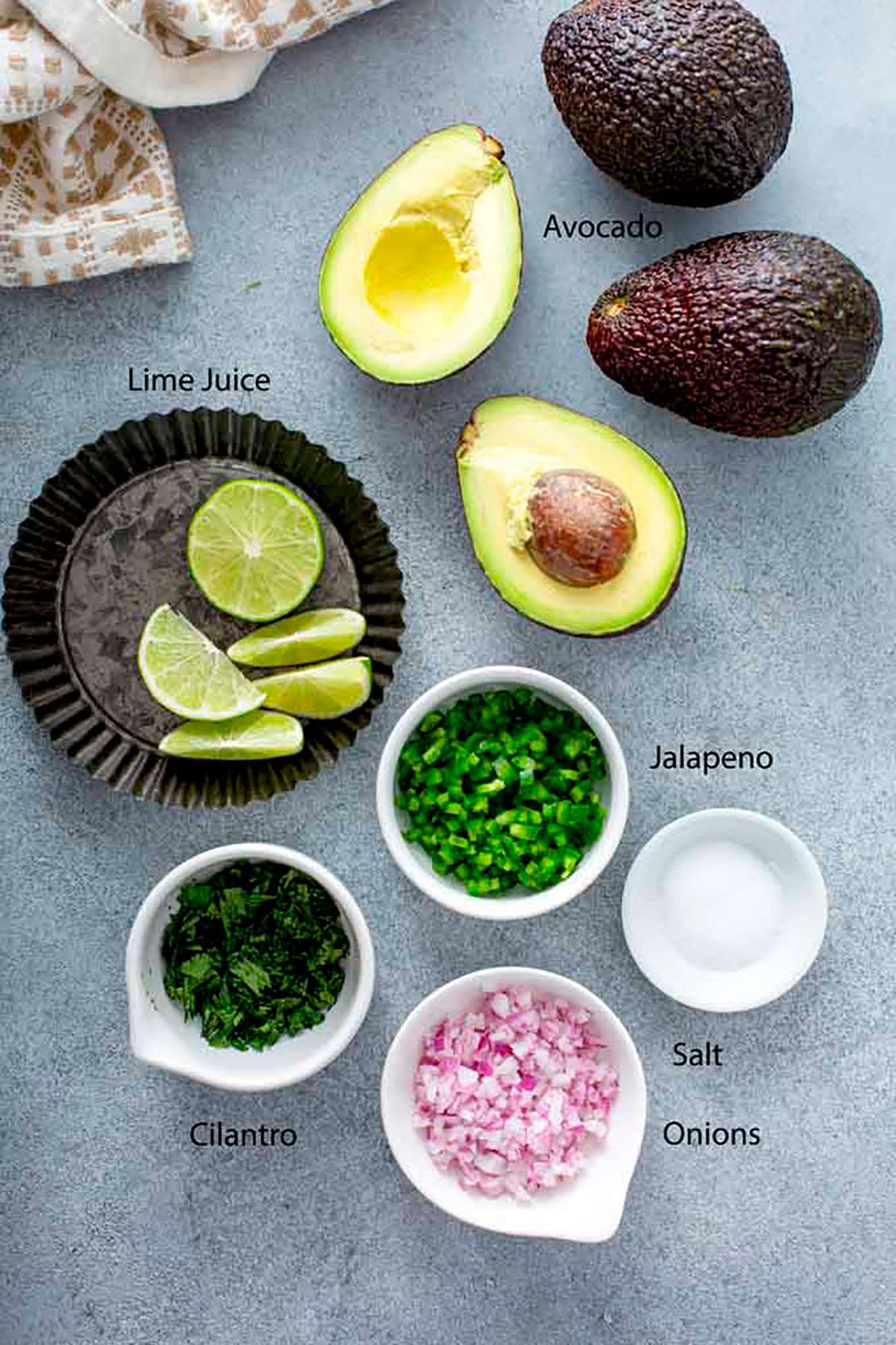 Ingredients to make guacamole on a gray surface