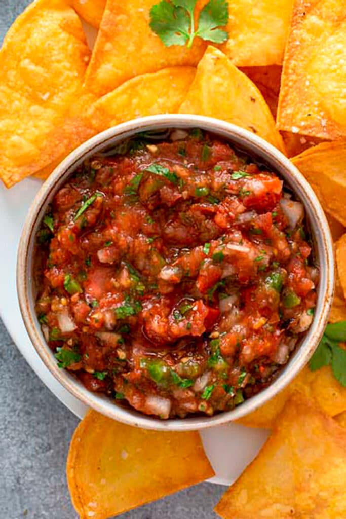 Top view of a bowl of fresh Mexican Salsa with homemade tortilla chips 